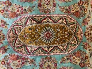 Azerbaijan Tappeti Milano Tappeto con motivi intricati, motivi floreali e una farfalla colorata nell'angolo in alto a destra.