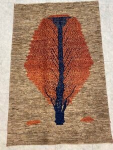 Azerbaijan Tappeti Milano Tappeto rettangolare con motivo centrale ad albero nei toni del blu e dell'arancione su sfondo beige screziato.