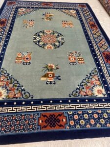 Azerbaijan Tappeti Milano Un tappeto blu con motivi floreali e geometrici bordati da motivi intricati.