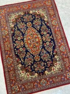 Azerbaijan Tappeti Milano Un tappeto colorato in stile persiano con intricati motivi floreali e un medaglione centrale su uno sfondo scuro.