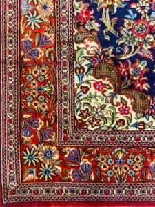 Azerbaijan Tappeti Milano Colorato tappeto in stile persiano con intricati motivi floreali nei toni del rosso, blu, crema e verde.