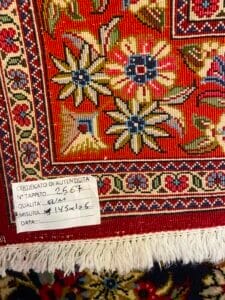 Azerbaijan Tappeti Milano Primo piano di un tappeto con motivi colorati, corredato di certificato di autenticità e dettagli scritti a mano.