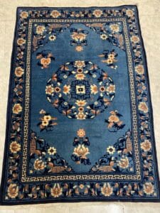 Azerbaijan Tappeti Milano Tappeto rettangolare blu con motivi floreali, medaglione centrale, bordo decorativo e adesivo a forma di farfalla.