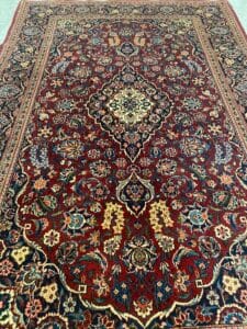 Azerbaijan Tappeti Milano Tappeto persiano decorato con sfondo rosso, intricati motivi floreali e un medaglione centrale a forma di diamante.