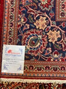 Azerbaijan Tappeti Milano Tappeto colorato e decorato con motivi floreali e un'etichetta del servizio di restauro in un angolo con note scritte a mano.